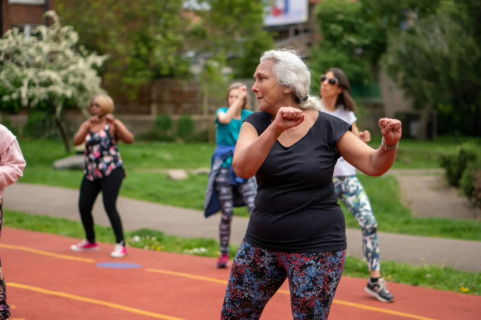 Femme aux cheveux gris pendant un cours de sport en extérieur